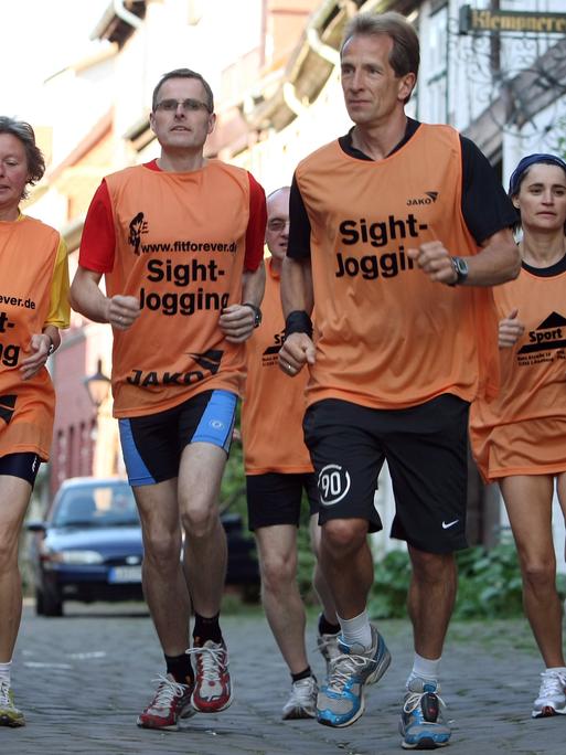 Mit einer Gruppe von Besuchern läuft der Stadtführer Jürgen Thies (3. v. rechts) durch Lüneburg (Foto vom 07.05.2008). Die Stadtführung der sportlichen Art ist in Niedersachsen angekommen. 