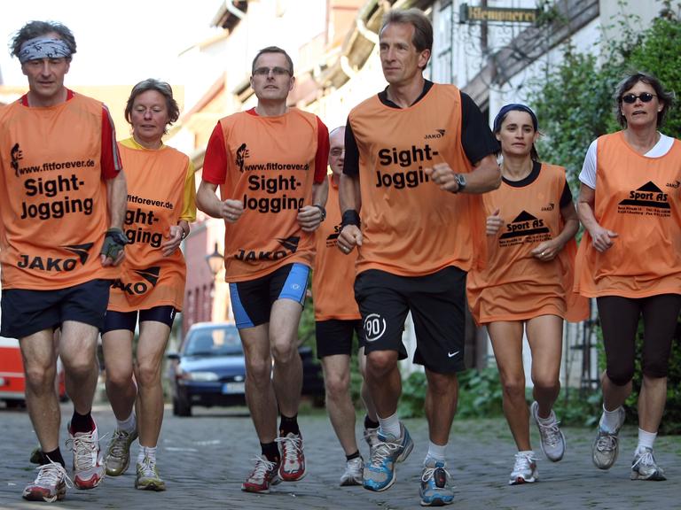 Mit einer Gruppe von Besuchern läuft der Stadtführer Jürgen Thies (3. v. rechts) durch Lüneburg (Foto vom 07.05.2008). Die Stadtführung der sportlichen Art ist in Niedersachsen angekommen. 