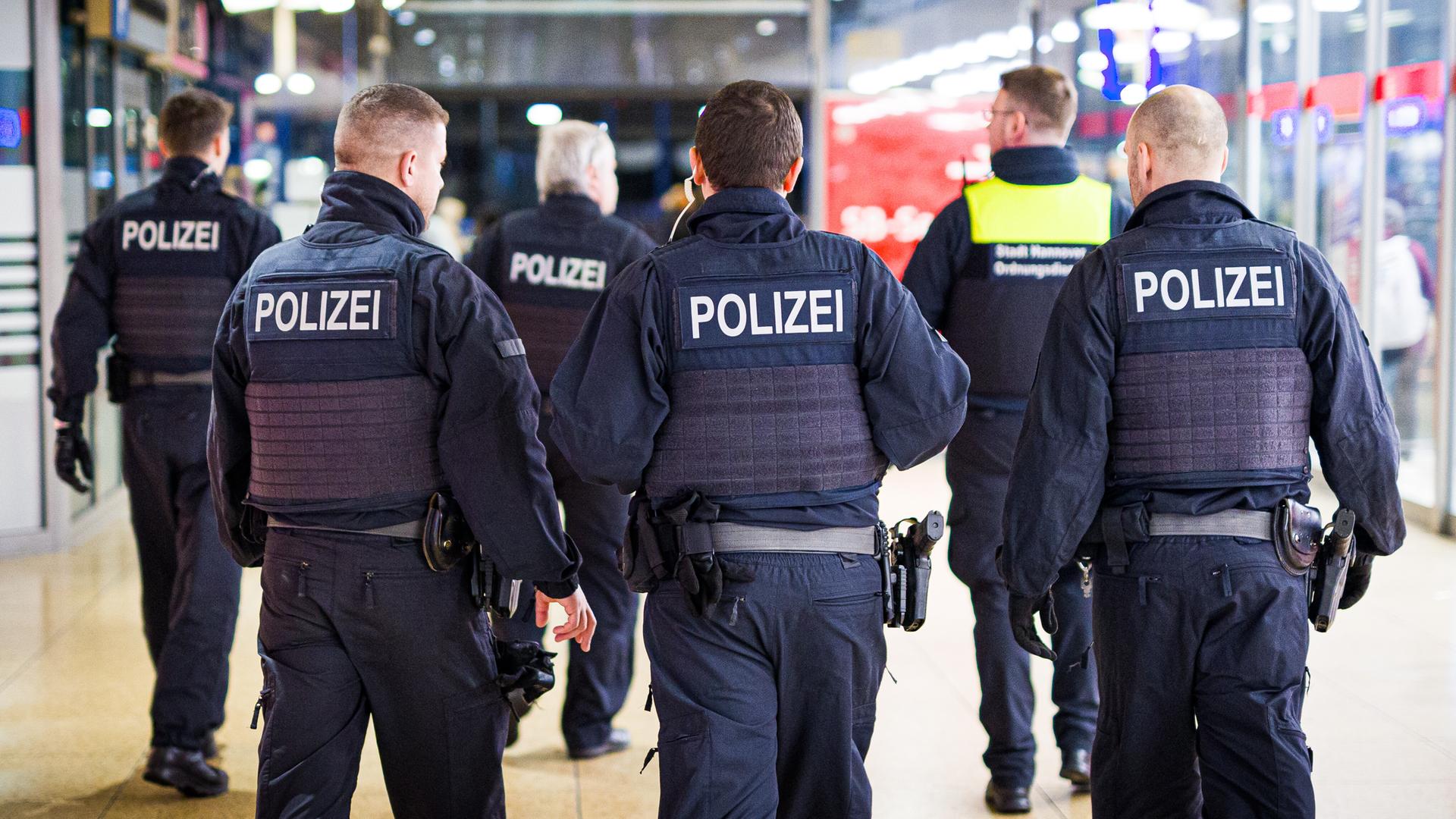 Einsatzkräfte von Bundespolizei und Ordnungsdienst der Stadt Hannover gehen durch den Hauptbahnhof. 