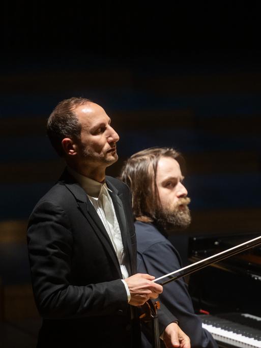 Ein Geiger steht mit geschlossenen Augen vor einem Pianisten.