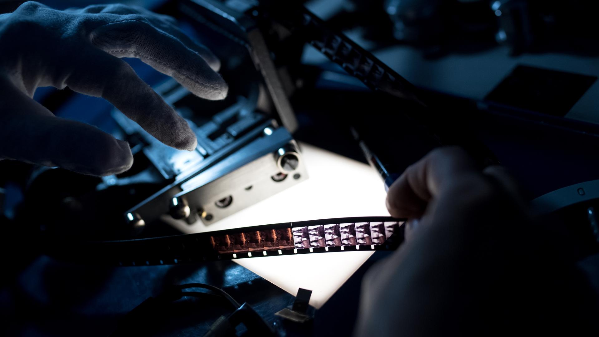 Eine Cutterin vom Bayerischen Rundfunk (BR) schneidet einen alten 35mm Film auf einem Schneidetisch