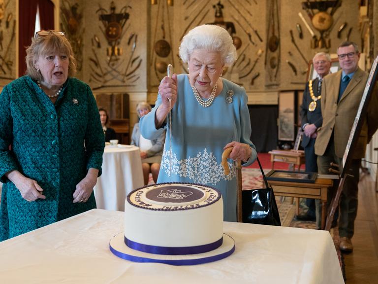Torte zum 70. Thronjubliäum: Elisabeth II. am 5. Februar 2022 in der königlichen Residenz in Norfolk:Torte zum Thronjubliäum : Die britische Königin Elisabeth II. schneidet am 5. F-ebruar 2022 in Sandringham House. der königlichen Residenz in Norfolk ein Festagstorte an