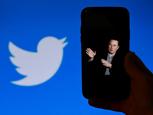 Elon Musk auf dem Display eines Smartphones, daneben das Twitterlogo.