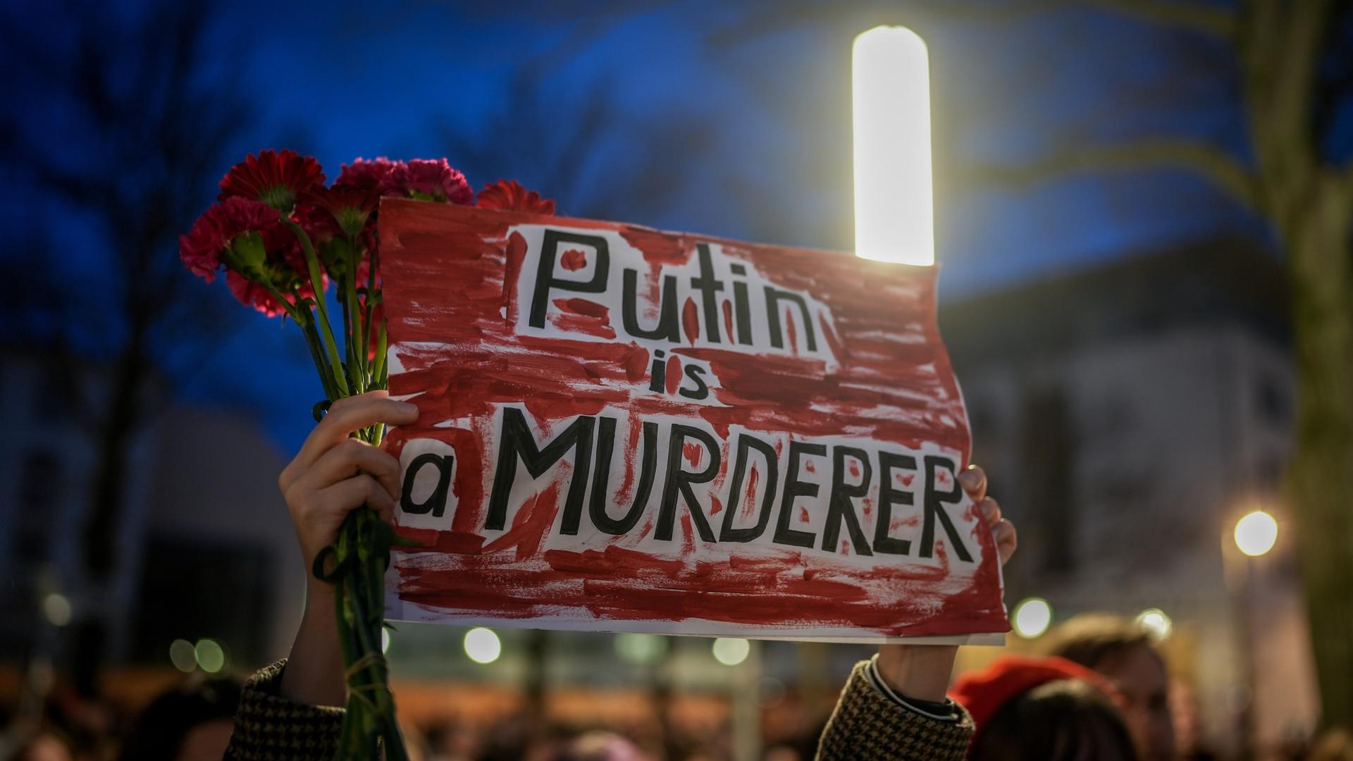 Demonstranten versammeln sich nach dem Tod von Alexej Nawalny mit einem Schild mit der Aufschrift "Putin is a murderer" (Putin ist ein Mörder) vor der russischen Botschaft in Berlin. 