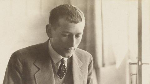 Der Architekt und Designer Marcel Breuer sitzt im Anzug mit Krawatte an einer Schreibmaschine und tippt. 