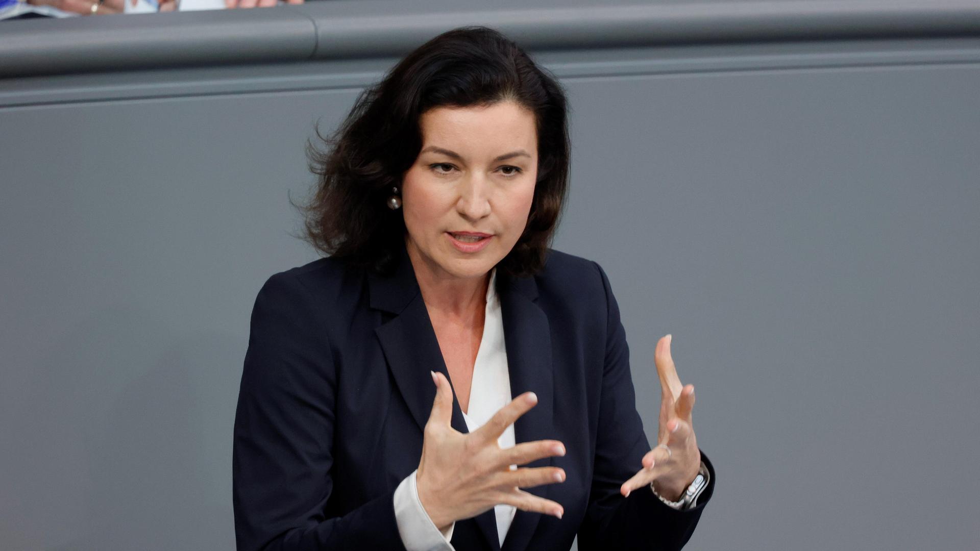 Eine Frau im Anzug spricht an einem Rednerpult im Bundestag.