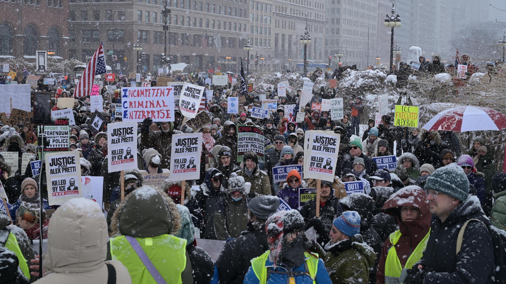 Demonstranten versammeln sich während eines heftigen Schneesturms auf der Michigan Avenue in Chicago, um mit Plakaten und Bannern gegen die Einwanderungsbehörde ICE zu protestieren.