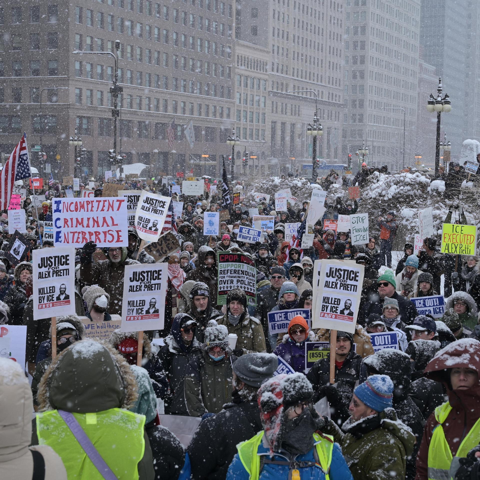 Demonstranten versammeln sich während eines heftigen Schneesturms auf der Michigan Avenue in Chicago, um gegen die US-Einwanderungs- und Zollbehörde (ICE) und die Zoll- und Grenzschutzbehörde (CBP) mit Plakaten und Bannern zu protestieren.