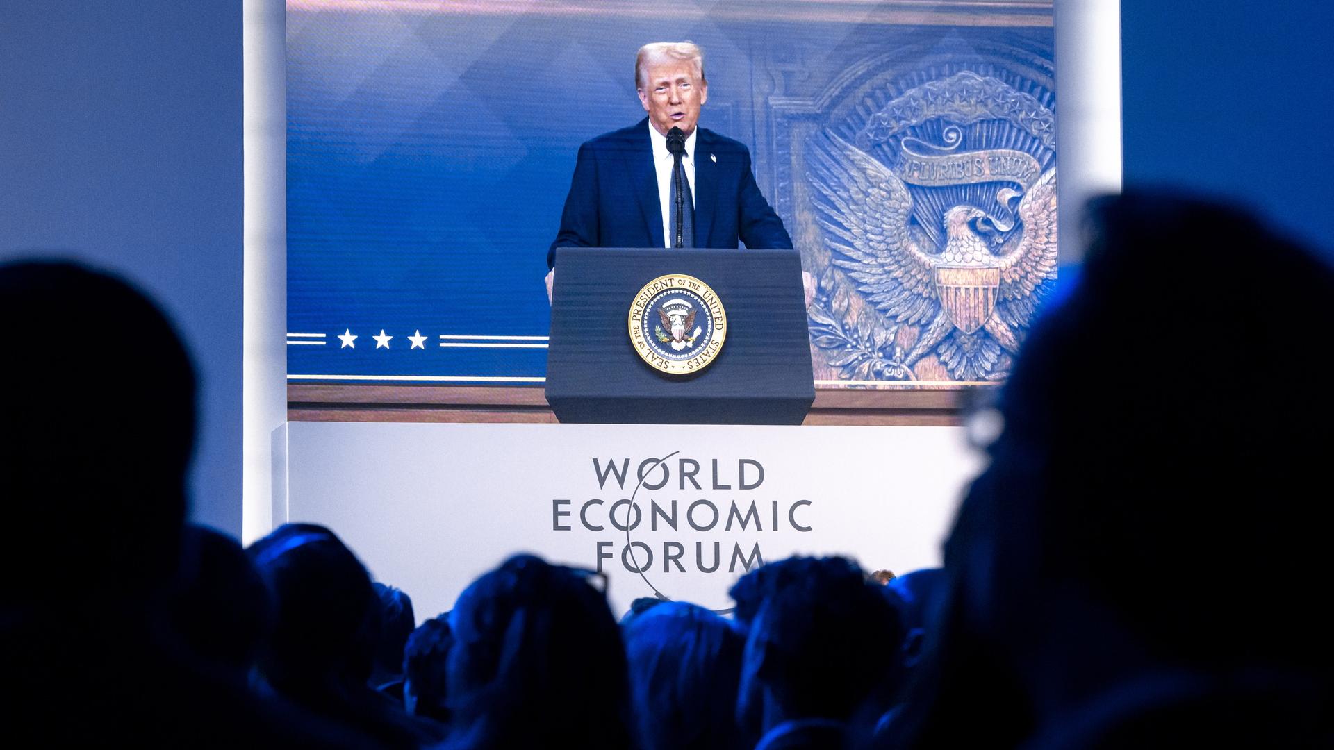 Menschen verfolgen eine virtuelle Rede von US-Präsident Donald Trump auf dem Jahrestreffen des Weltwirtschaftsforums in Davos.