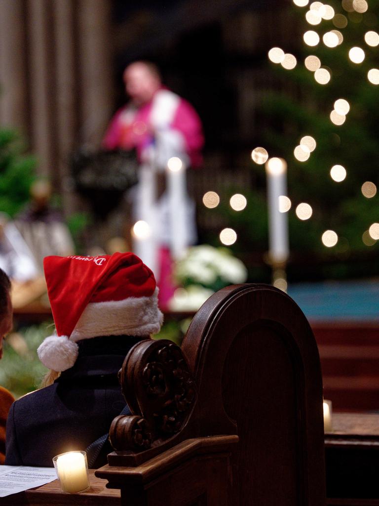 Stadtdechant Robert Kleine leitet die Christvesper im Kölner Dom am Heiligen Abend, Besucher mit Weihnachtsmütze 