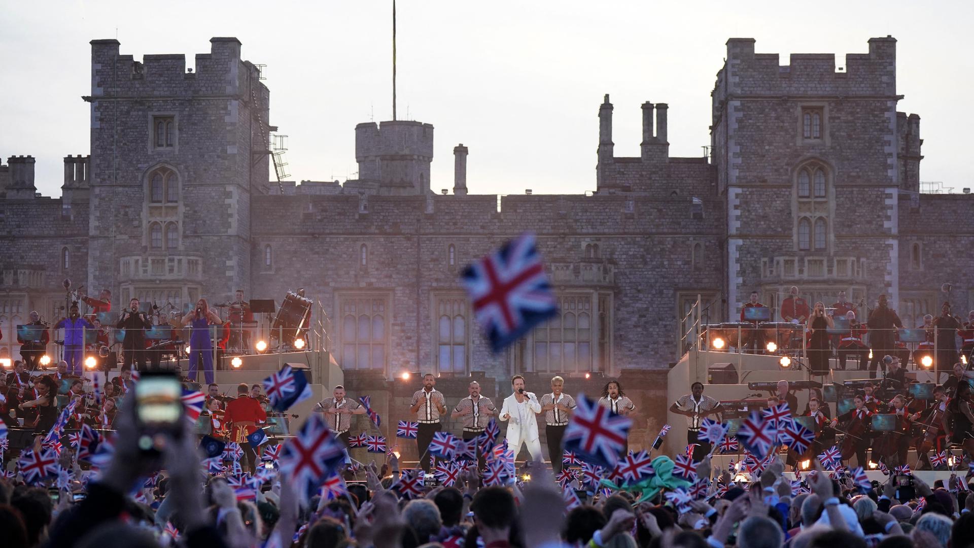 Zu sehen ist eine Konzertbühne vor Schloss Windsor. Namhafte Popmusiker feierten dort die Krönung von Charles und Camilla mit 20.000 Zuschauern. Zu sehen ist eine Konzertbühne vor Schloss Windsor. Namhafte Popmusiker feierten dort die Krönung von Charles und Camilla mit 20.000 Zuschauern.