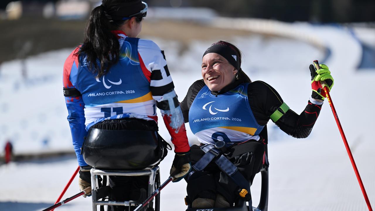 Anja Wicker (r) aus Deutschland sitzt auf ihrem Bi-Ski. Sie lacht und schaut Yunji Kim (l) aus Südkorea an.