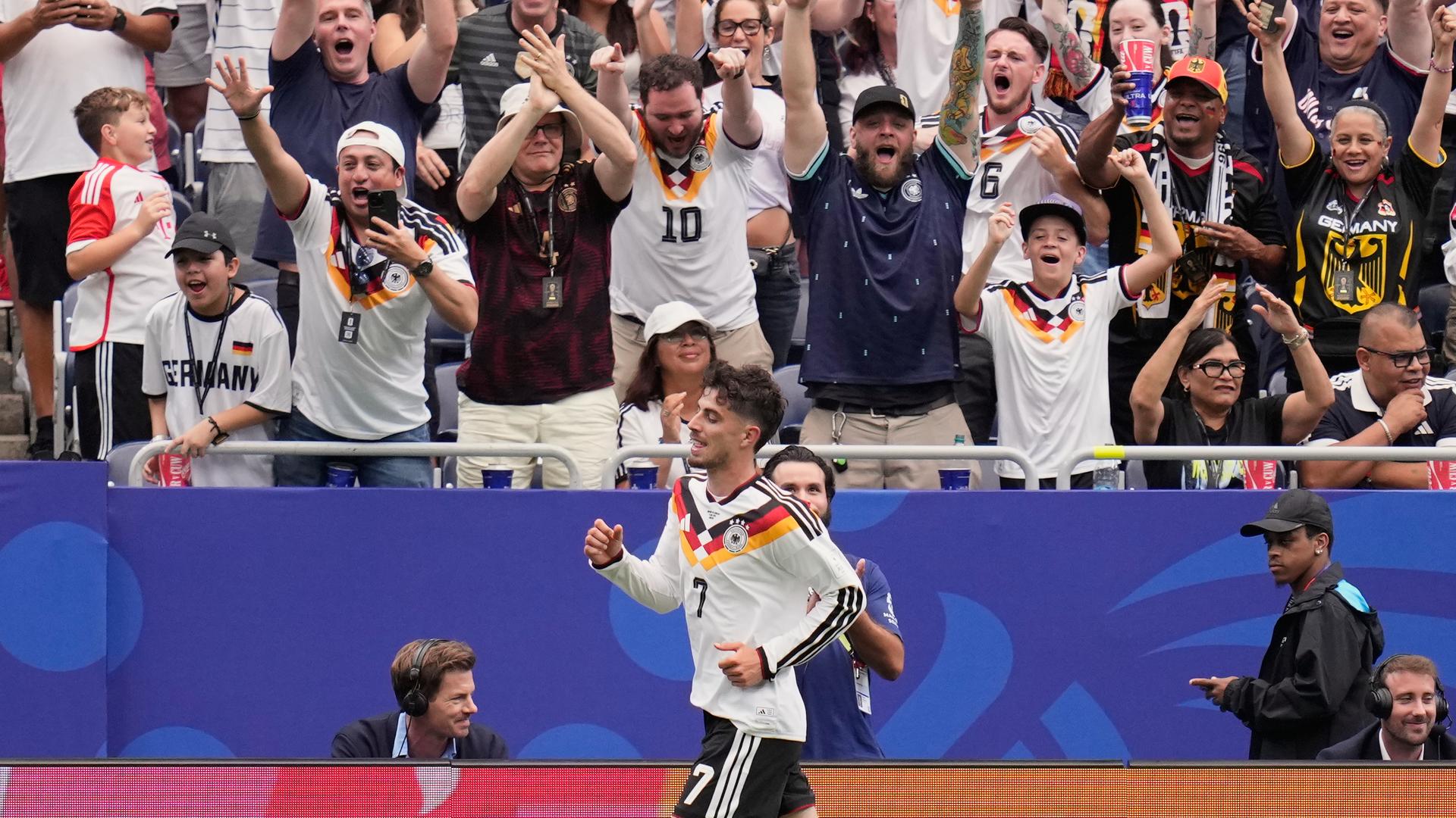 Kai Havertz läuft an der Tribüne mit feiernden Fans vorbei. Kai Havertz läuft an der Tribüne mit feiernden Fans vorbei.