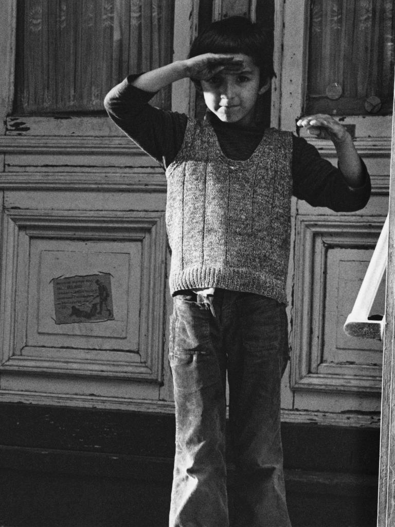 Ein türkischer Junge in Berlin-Kreuzberg 1976 steht vor einer Haustür und hält seine rechte Hand als Schutz gegen die Sonne über die Augen. Ein türkischer Junge in Berlin-Kreuzberg 1976 steht vor einer Haustür und hält seine rechte Hand als Schutz gegen die Sonne über die Augen.