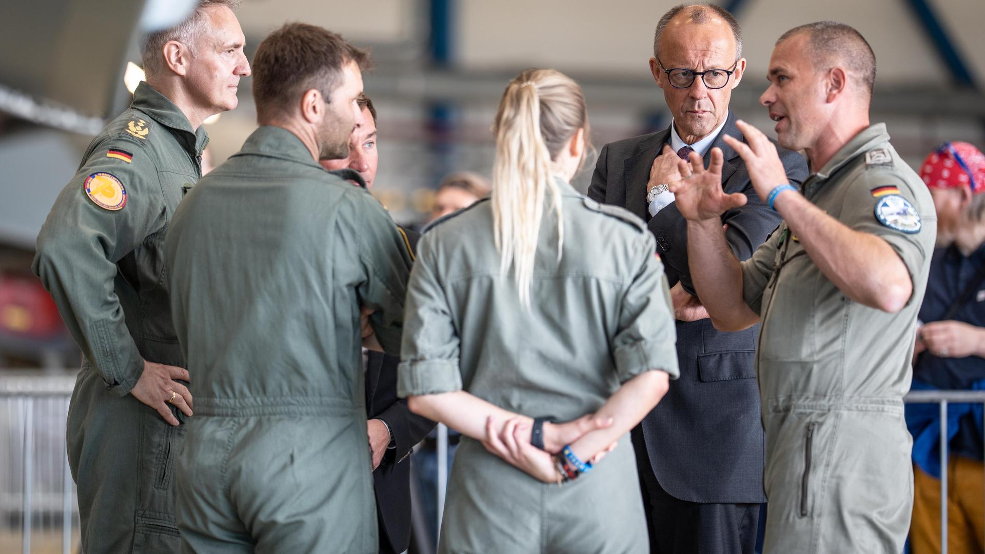 Bundeskanzler Friedrich Merz tauscht sich vor einem Kampfjet mit Soldaten und Soldatinnen aus. Bundeskanzler Friedrich Merz tauscht sich vor einem Kampfjet mit Soldaten und Soldatinnen aus.