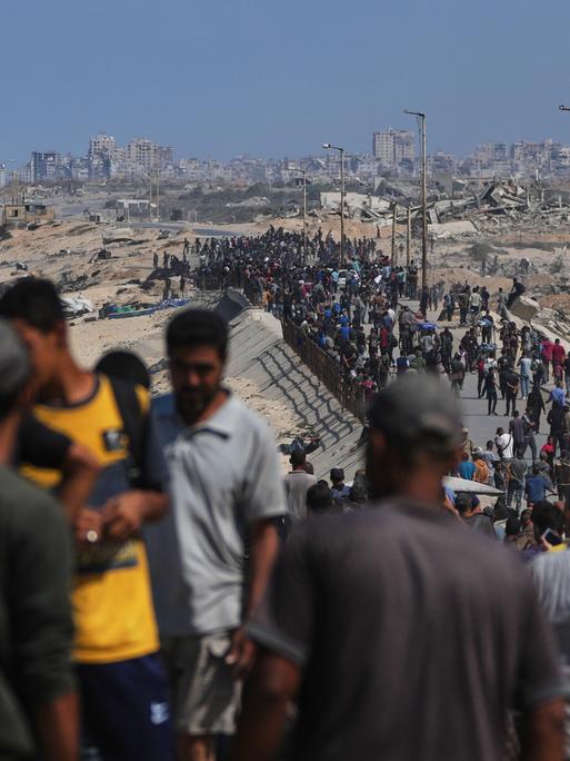 Bewohner des Gazastreifens gehen an der Küste entlang zu ihren Wohngebieten.
