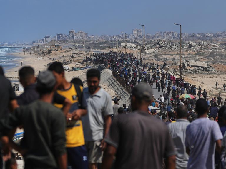 Bewohner des Gazastreifens gehen an der Küste entlang zu ihren Wohngebieten.