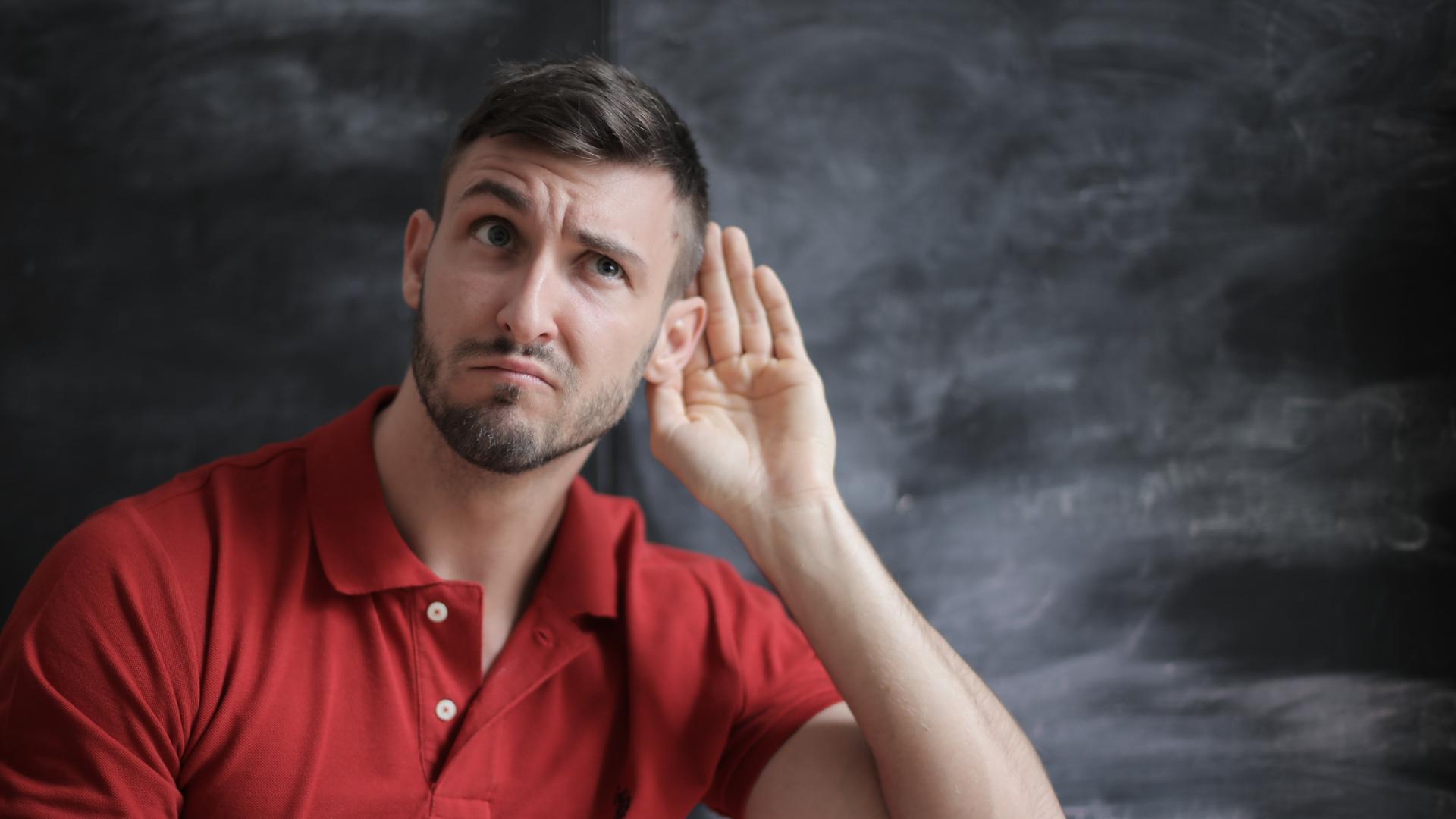 Ein Mann hält sich die hand ans Ohr, um besser hin zu hören. Ein Mann hält sich die hand ans Ohr, um besser hin zu hören.