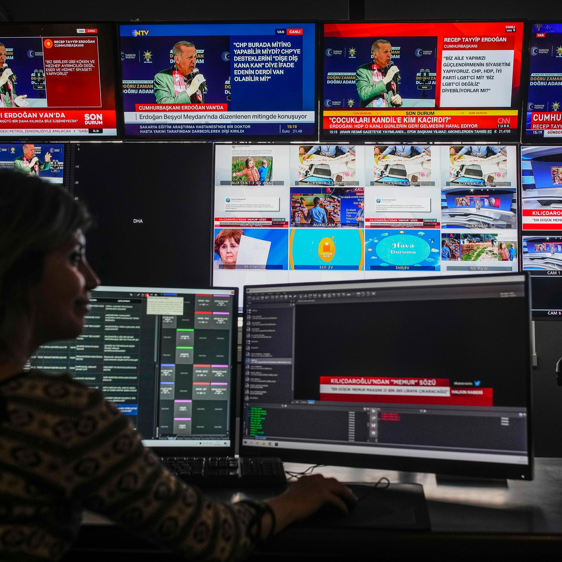 Eine Person sitzt beim türkischen Sender "Halk TV" vor mehreren Monitoren.  