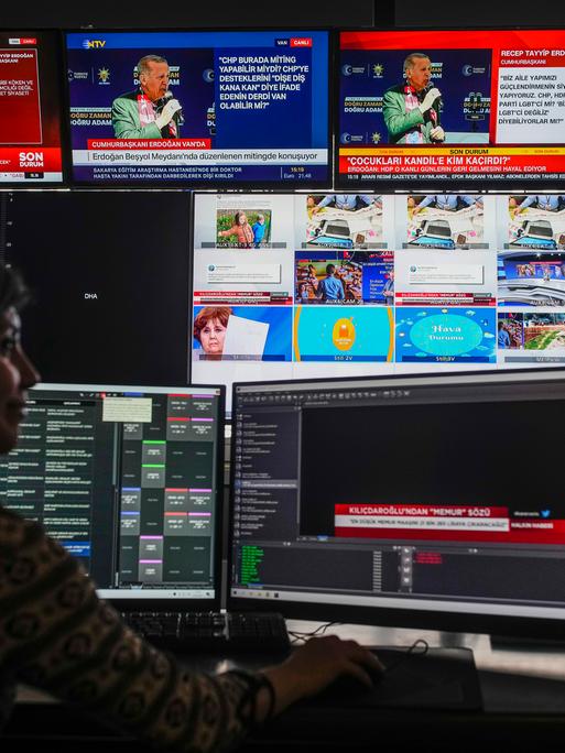 Eine Person sitzt beim türkischen Sender "Halk TV" vor mehreren Monitoren.