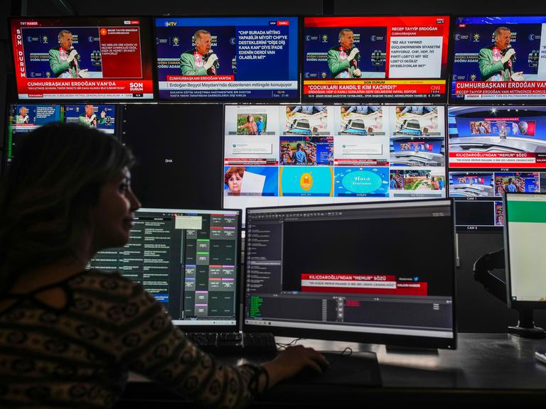 Eine Person sitzt beim türkischen Sender "Halk TV" vor mehreren Monitoren.