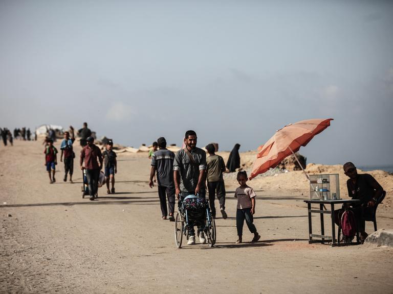 Palästinenser sind zu Fuß unterwegs in Gaza City im Gazastreifen.