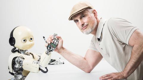 Ein Mann mittleren Alters (Informatiker und IDSIA Direktor Jürgen Schmidbauer) posiert beim Armdrücken mit dem humanoiden iCub-Roboter im Institut für künstliche Intelligenz IDSIA in Manno bei Lugano. Ein Mann mittleren Alters (Informatiker und IDSIA Direktor Jürgen Schmidbauer) posiert beim Armdrücken mit dem humanoiden iCub-Roboter im Institut für künstliche Intelligenz IDSIA in Manno bei Lugano.