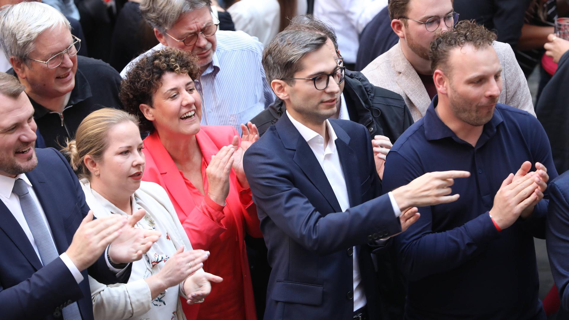 Mehrere Personen stehen nebeneinander und klatschen.