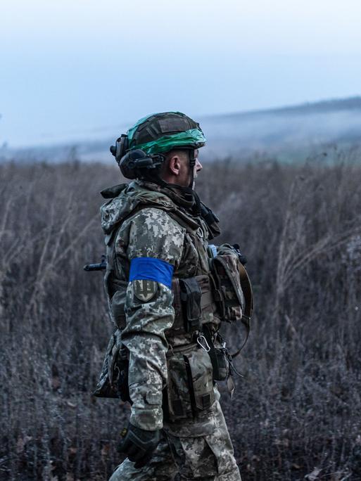 Ein ukrainischer Soldat steht in der Region Oblast in einem Feld.