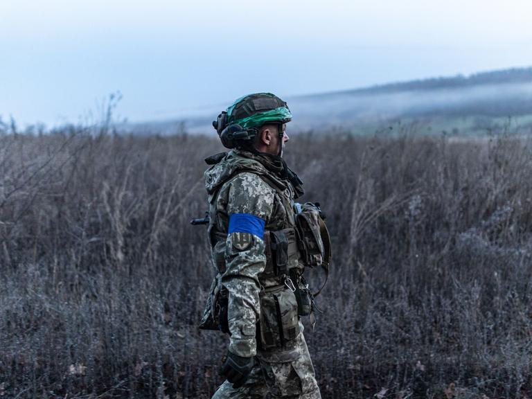 Ein ukrainischer Soldat steht in der Region Oblast in einem Feld.