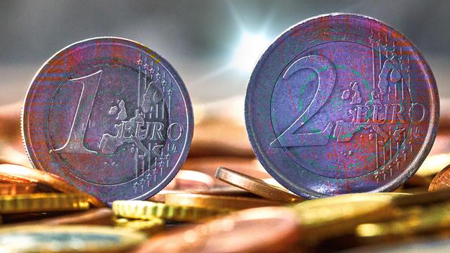 Fotomontage: zwei Euromünzen im Fokus, dahinter digitales Rauschen. Symbolbild für die anstehende Einführung des digitalen Euro. Fotomontage: zwei Euromünzen im Fokus, dahinter digitales Rauschen. Symbolbild für die anstehende Einführung des digitalen Euro.