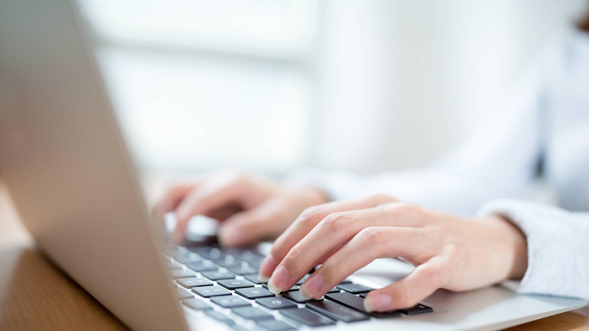 frauenhände schreiben am laptop-computer