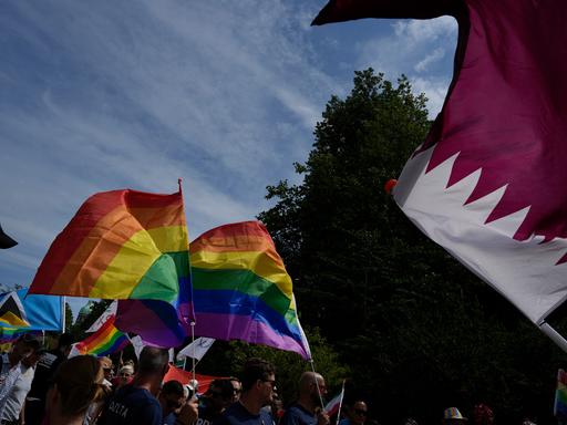 Teilnehmer bei der niederländischen Pride Parade. Daneben weht die katarischen Nationalflagge. 