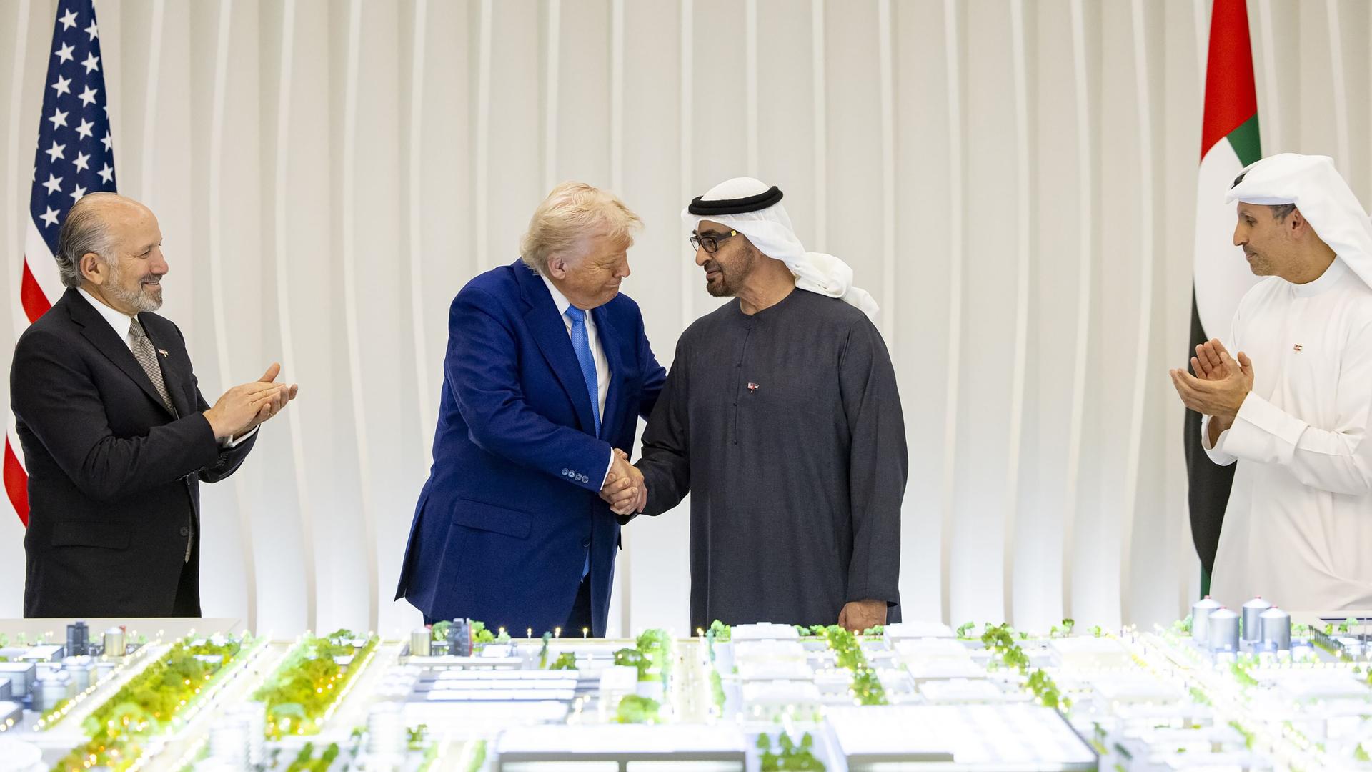 Donald Trump und Mohammed bin Zayed Al Nahyan stehen bei einem offiziellen Empfang vor einer Flagge der USA und der VAE vor einem Architekturmodell.