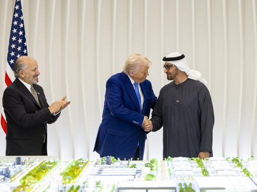 Donald Trump und Mohammed bin Zayed Al Nahyan stehen bei einem offiziellen Empfang vor einer Flagge der USA und der VAE vor einem Architekturmodell. Donald Trump und Mohammed bin Zayed Al Nahyan stehen bei einem offiziellen Empfang vor einer Flagge der USA und der VAE vor einem Architekturmodell.