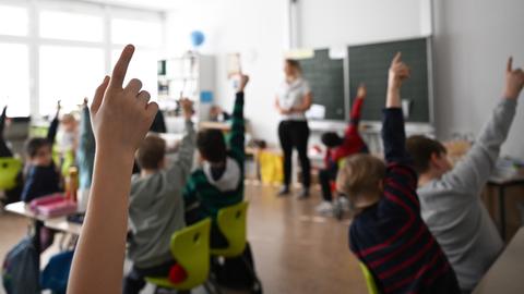 Schüler einer Grundschule arbeiten in einem Klassenzimmer an Mathematikaufgaben. 