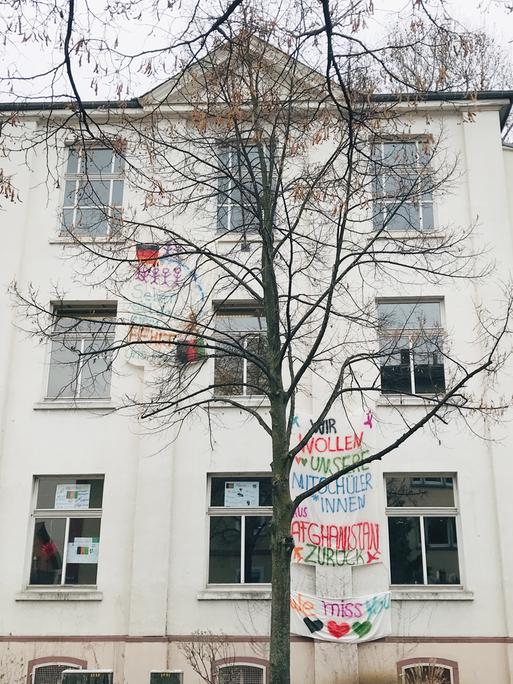 An der Hostatoschule in Frankfurt hängen Bettlaken an der Fassade. Auf einem steht "Wir wollen unsere Mitschüler aus Afghanistan zurück".