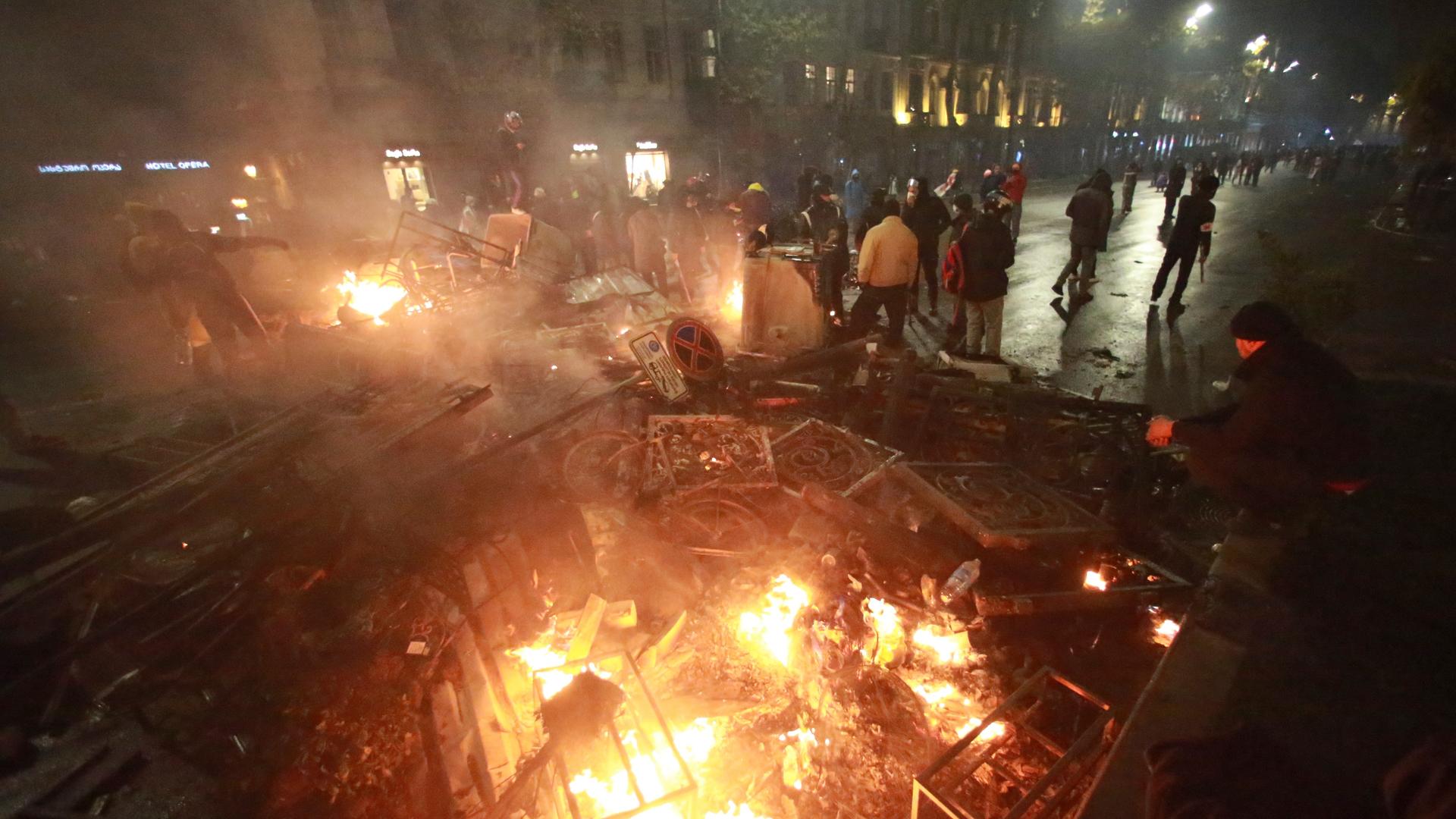 Tiflis: Demonstranten stehen neben einer brennenden Barrikade während einer Kundgebung gegen die Entscheidung der Regierung, die Verhandlungen über den Beitritt zur Europäischen Union für vier Jahre auszusetzen, vor dem Parlamentsgebäude in Tiflis.