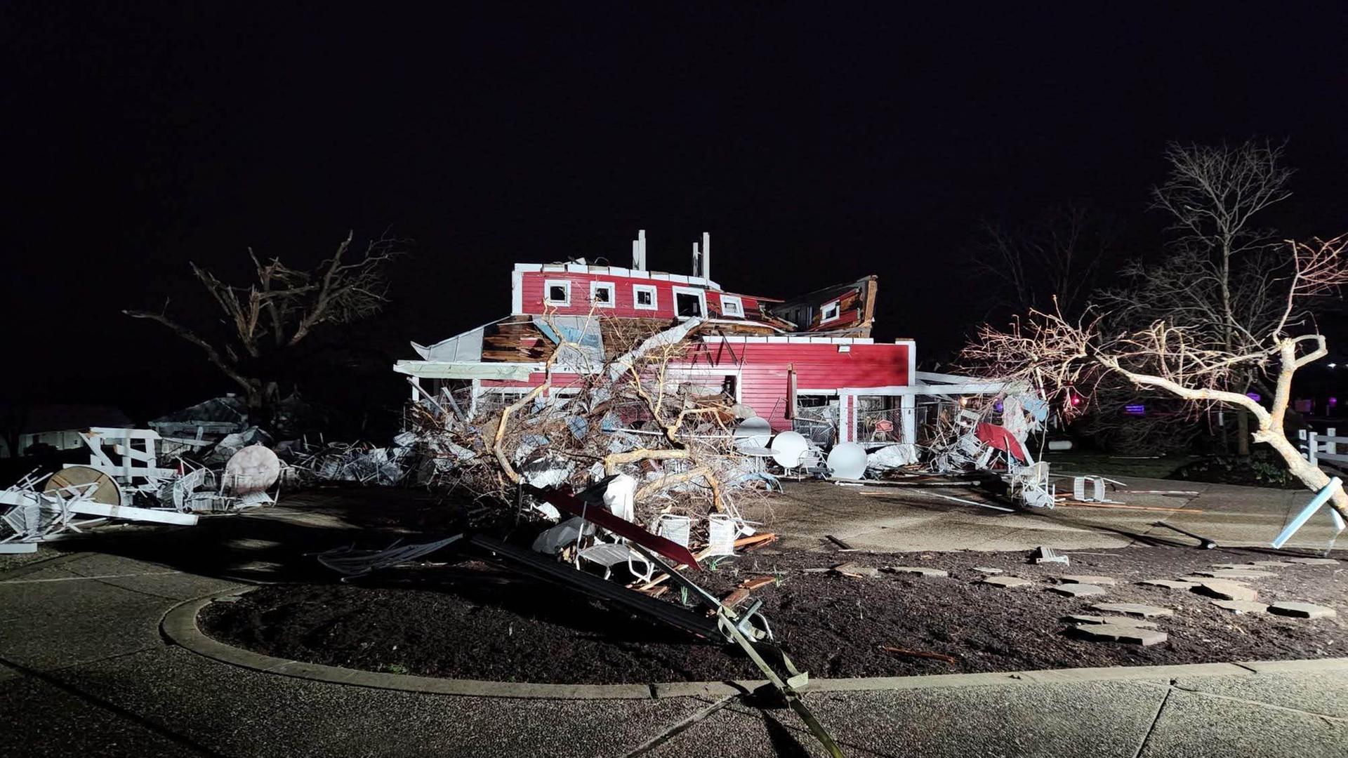 Das Bild zeigt ein vom Sturm zerstörtes Wohnhaus und umgestürzte Bäume.