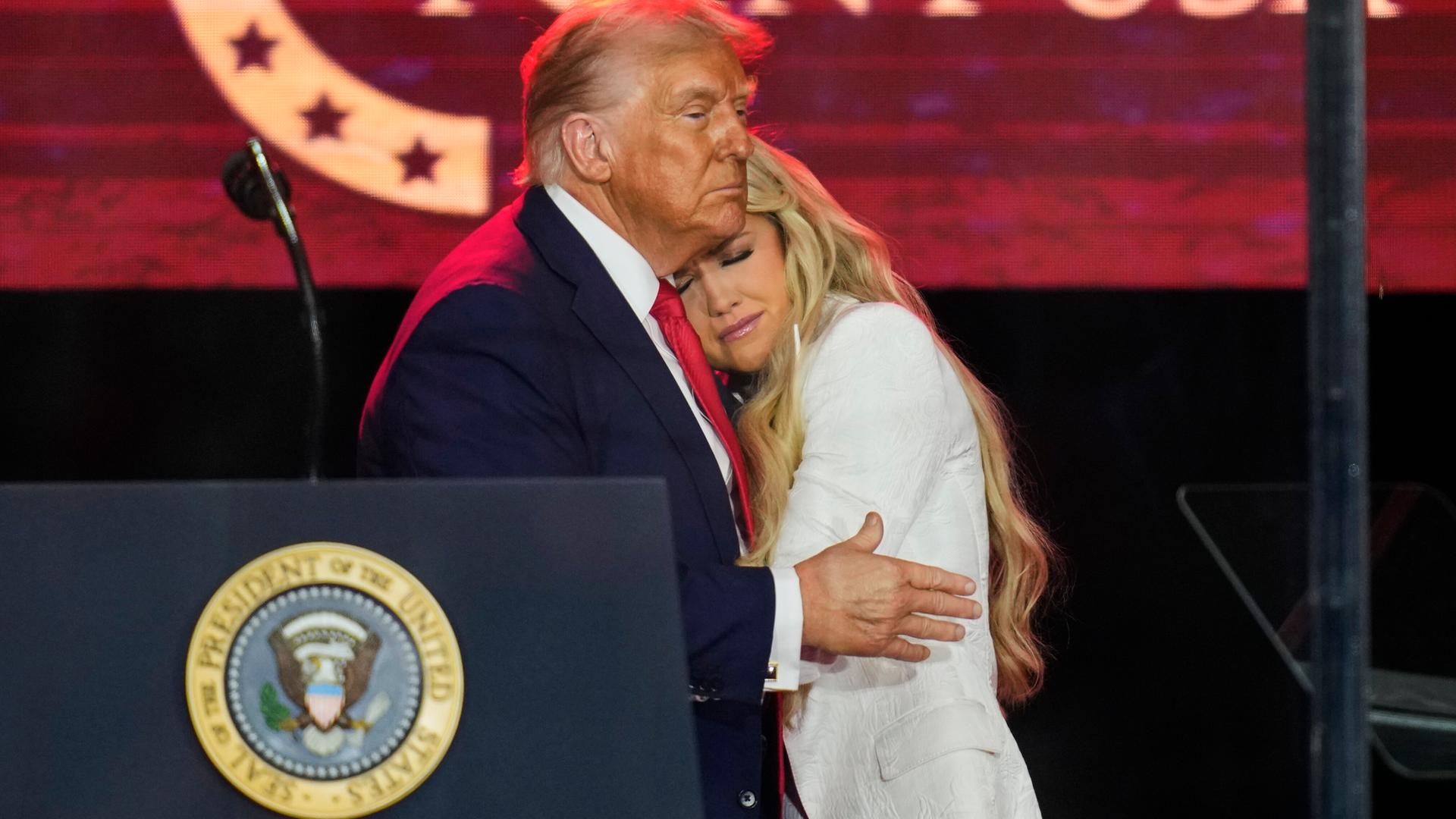 Präsident Donald Trump umarmt Witwe Erika Kirk bei der Gedenkfeier für den ultrarechten Aktivisten Charlie Kirk am Sonntag, 21. September 2025, im State Farm Stadium in Glendale, Arizona.