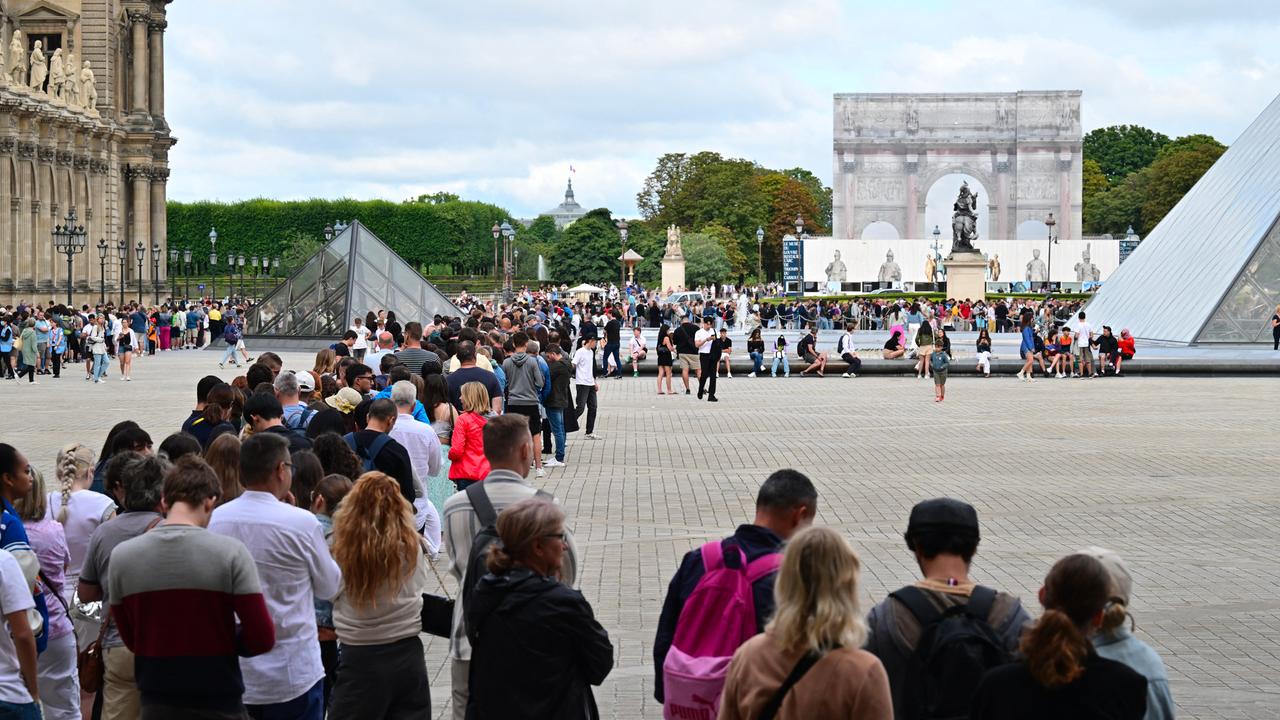 Besucher stehen Schlange, um das Louvre-Museum in Paris zu betreten.