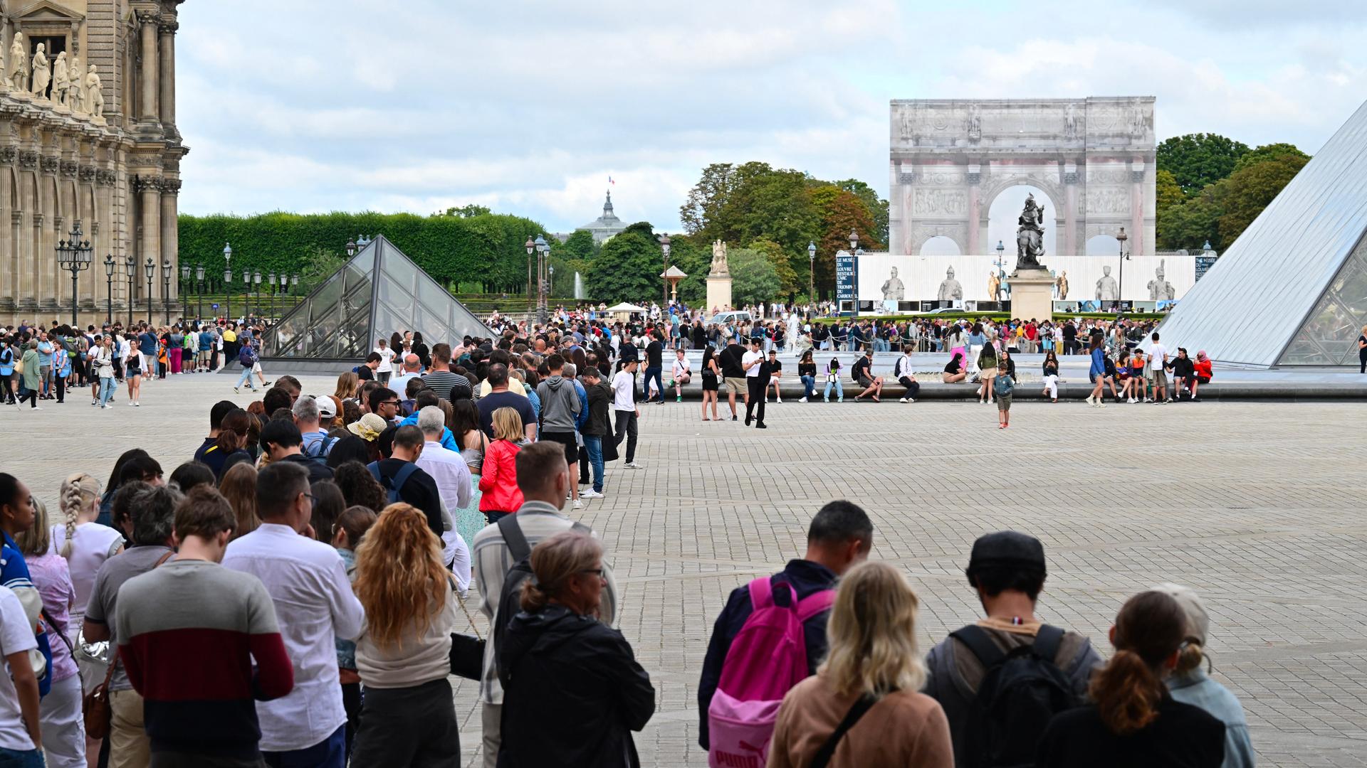 Besucher stehen Schlange, um das Louvre-Museum in Paris zu betreten. Besucher stehen Schlange, um das Louvre-Museum in Paris zu betreten.