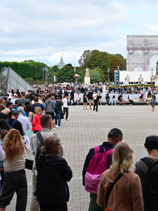 Besucher stehen Schlange, um das Louvre-Museum in Paris zu betreten.