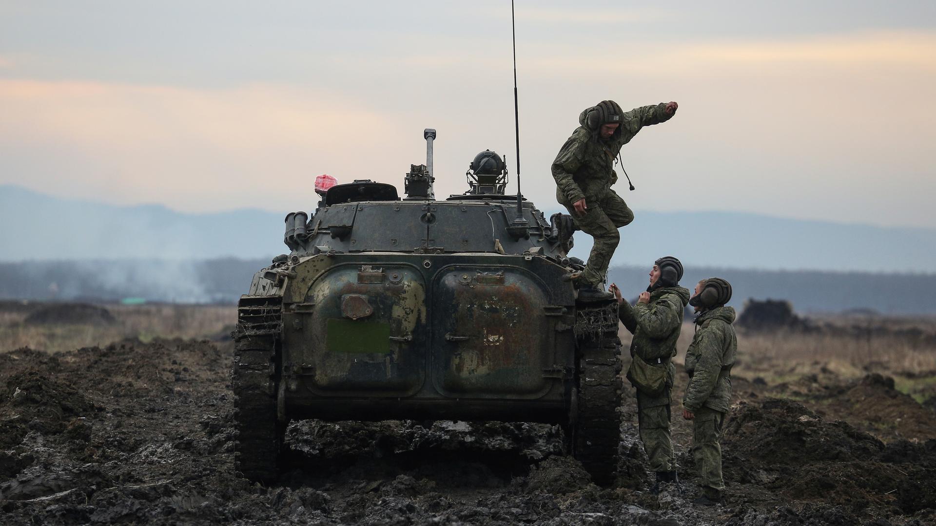 Russische Soldaten springen von einem Panzer bei einer Übung in der Nähe zur ukrainischen Grenze