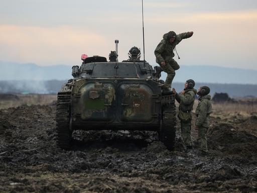 Russische Soldaten springen von einem Panzer bei einer Übung in der Nähe zur ukrainischen Grenze