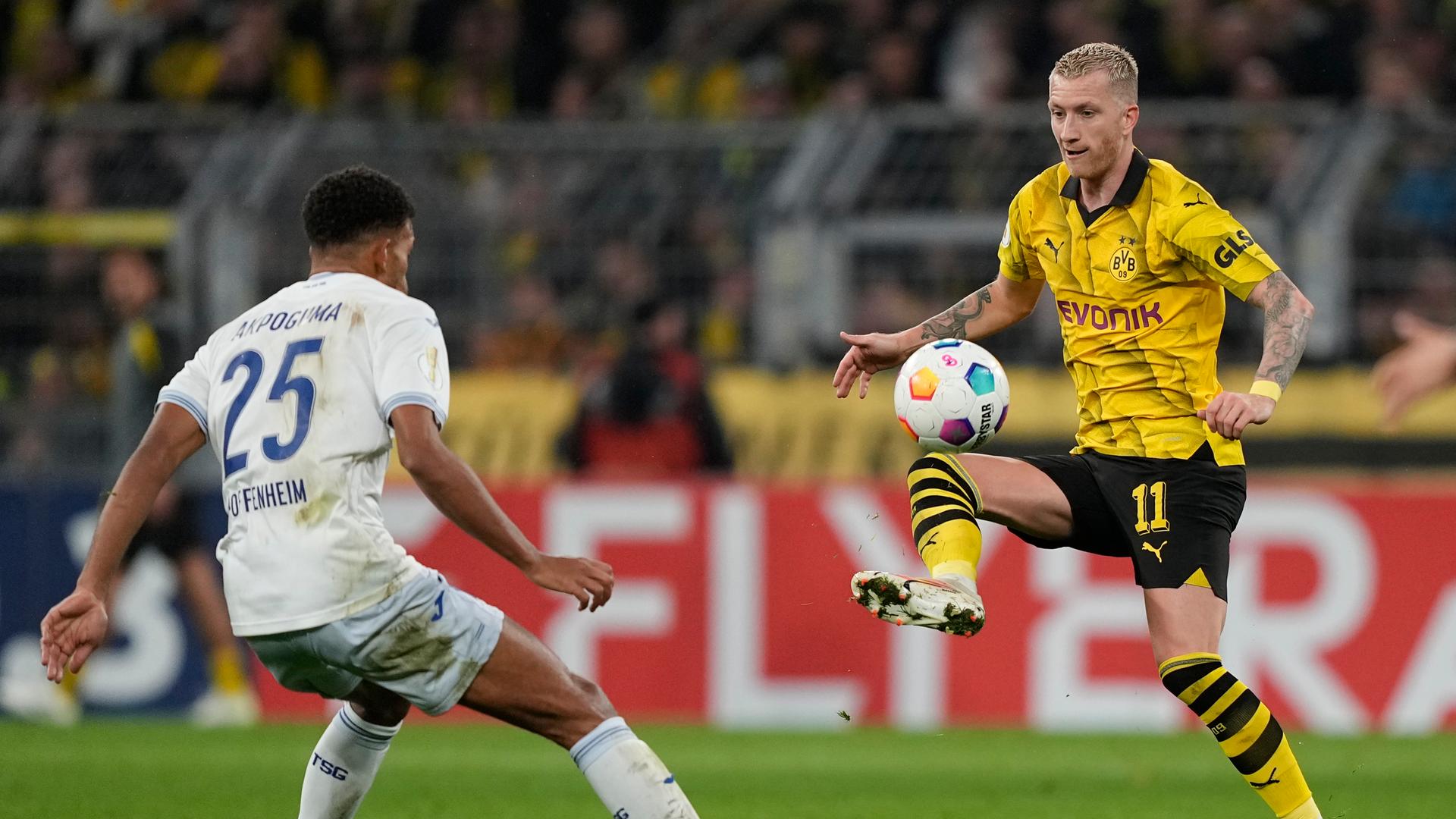 Dortmunds Marco Reus nimmt einen halbhohen Ball mit dem rechten Fuß an, ihm steht ein Hoffenheimer Spieler gegenüber.