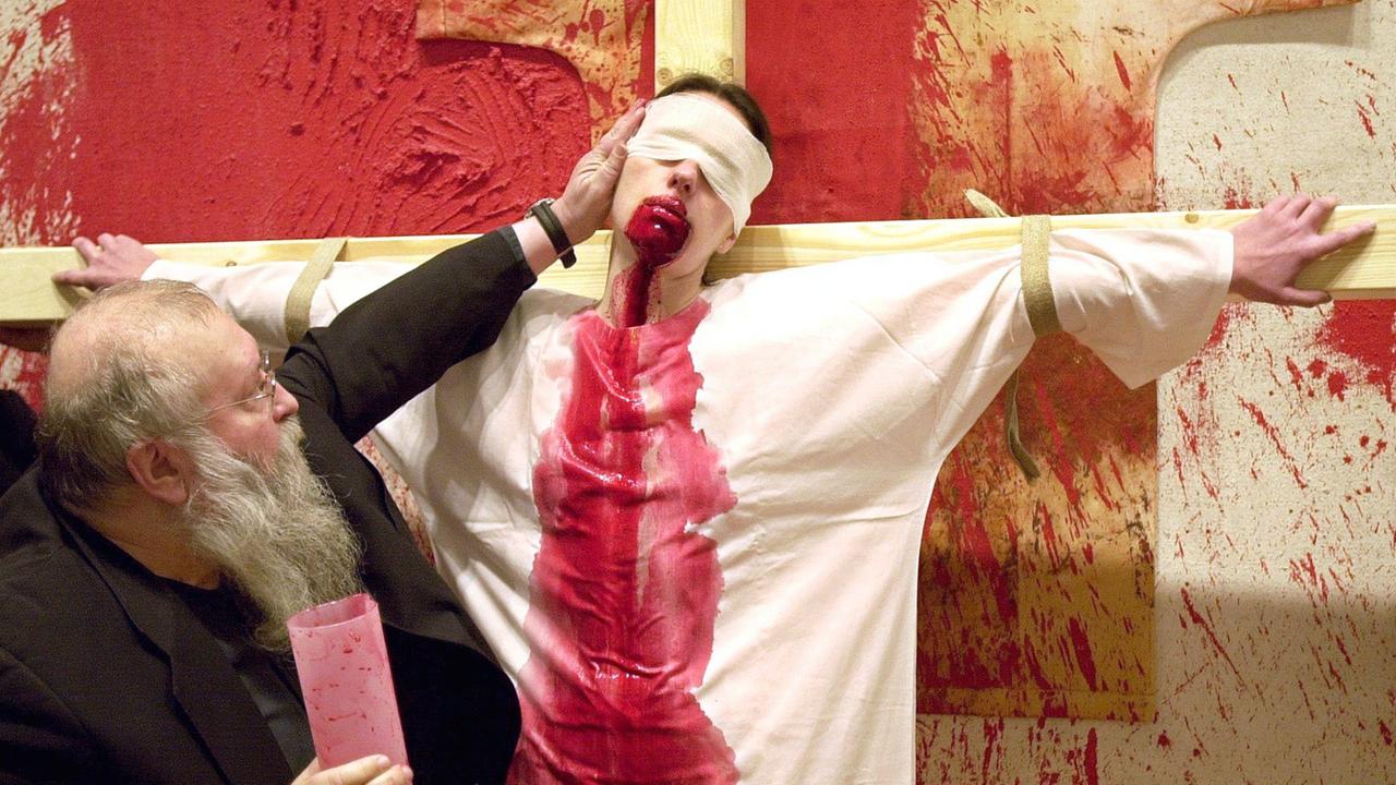 Der österreichische Künstler Hermann Nitsch steht vor einem Model, das mit Schweineblut bemalt ist Der österreichische Künstler Hermann Nitsch steht vor einem Model, das mit Schweineblut bemalt ist