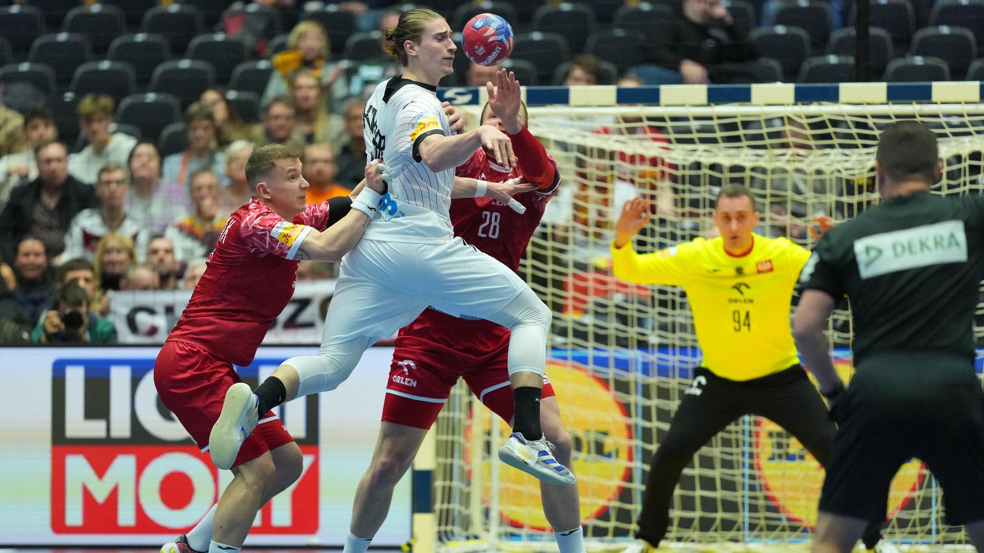 Auftakt der Handball-WM: Deutschland spielt gegen Polen; Spieler beider Nationalmannschaften kämpfen um den Ball.