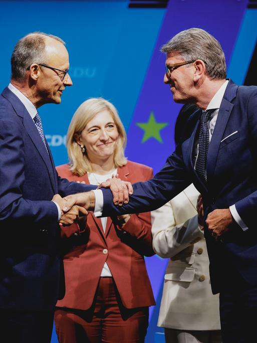 Friedrich Merz schüttelt Wolfram Weimer die Hand. Zwischen ihnen steht die CDU-Parteivorsitzender, Nina Warken, designierte Bundesministerin für Gesundheit. 