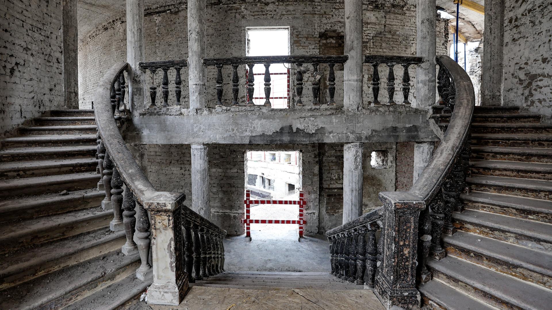 Blick in den Treppenaufgang des zerstörten Theaters von Mariupol mit Brandspuren und Schutt auf den Stufen
